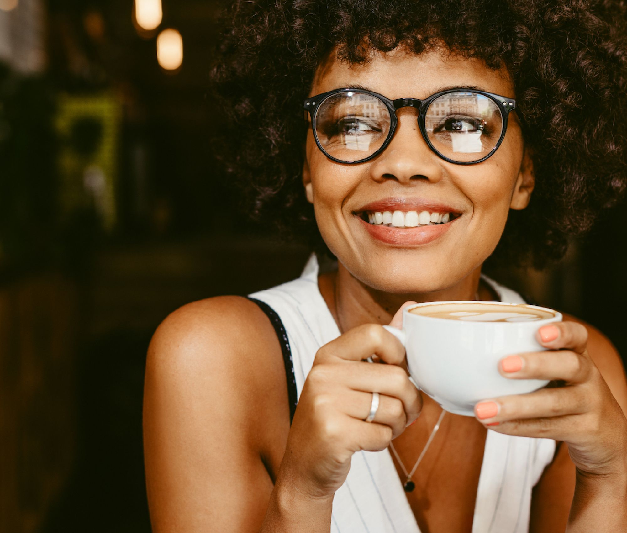Woman smiling holding a coffee mug