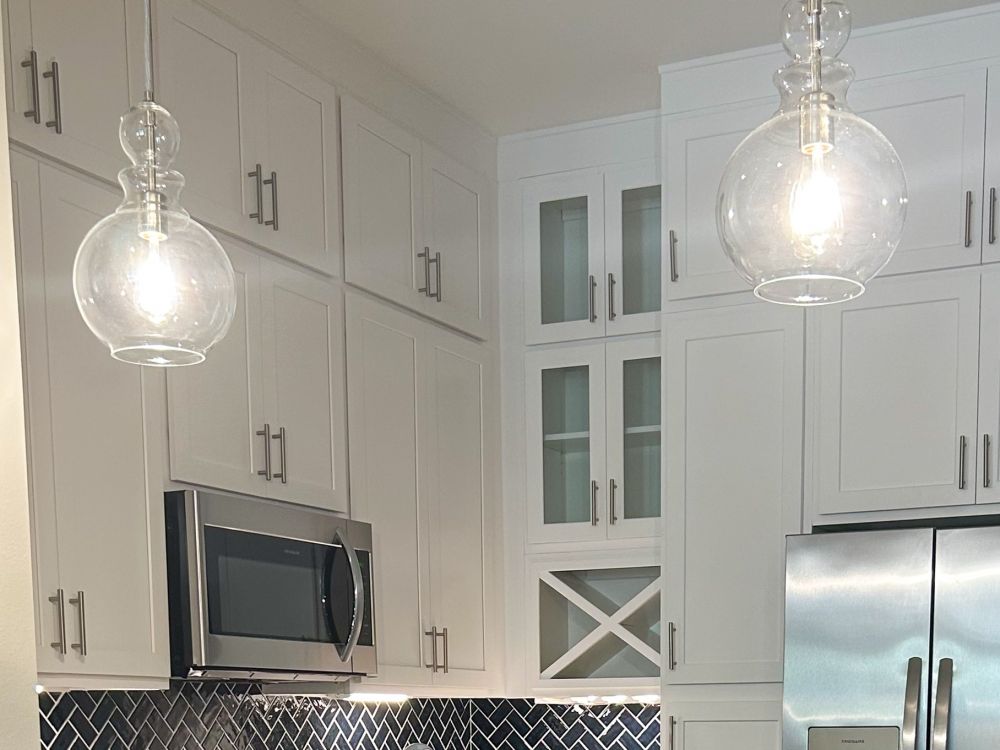 Kissimmee, FL apartment kitchen with designer lighting and elegant cabinetry