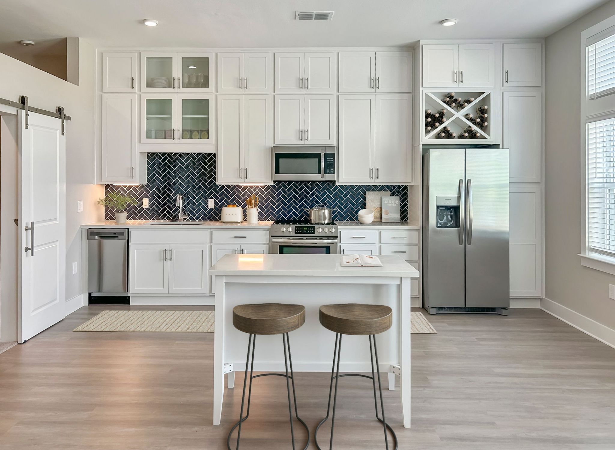 Luxury one bedroom apartment kitchen with quartz countertops, tile backsplash, and stainless steel appliances