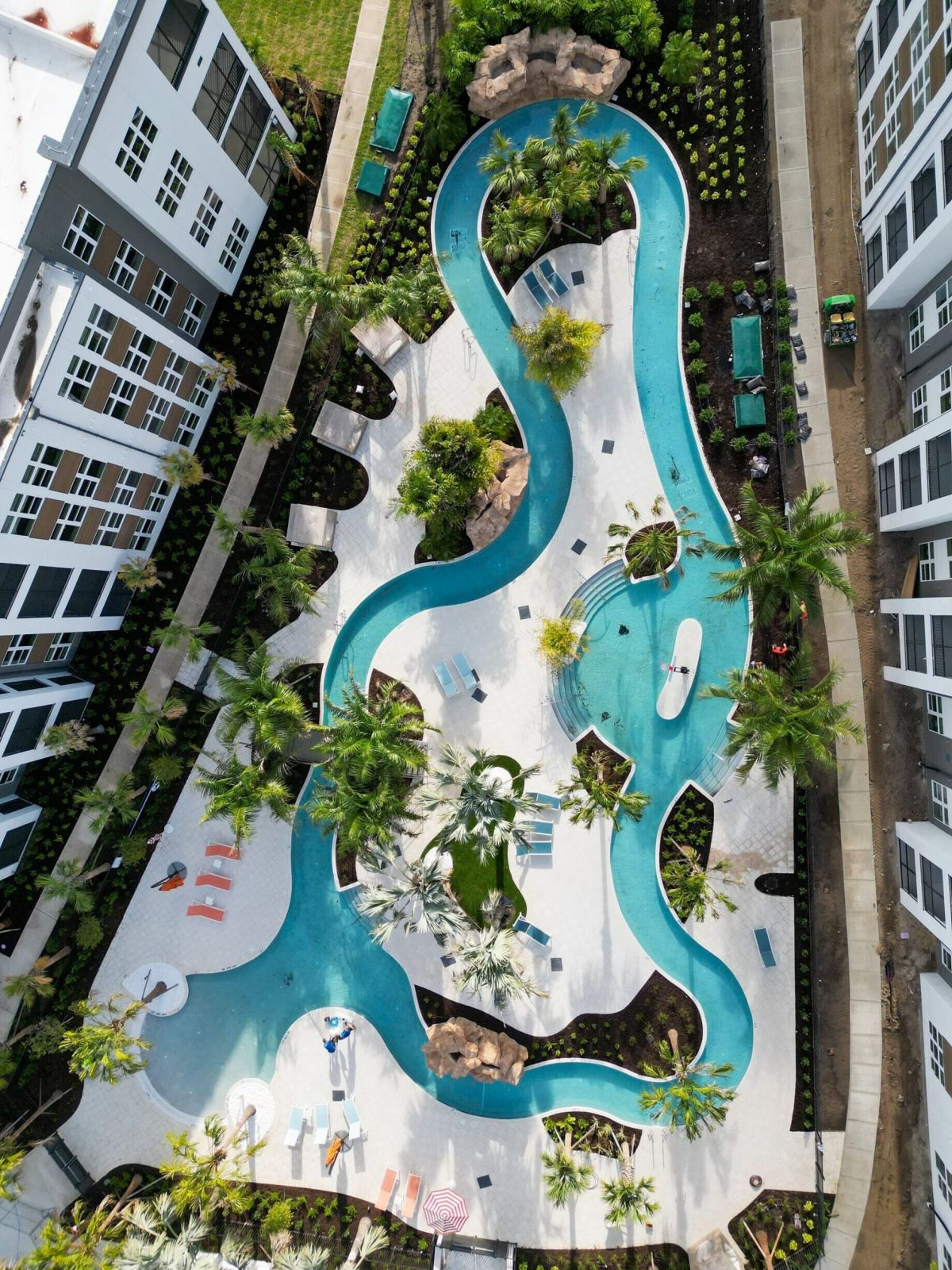 Aerial view of our 23,000 sq. ft. lazy river surrounded by trees and lounge chairs at The Lucent at Sunrise