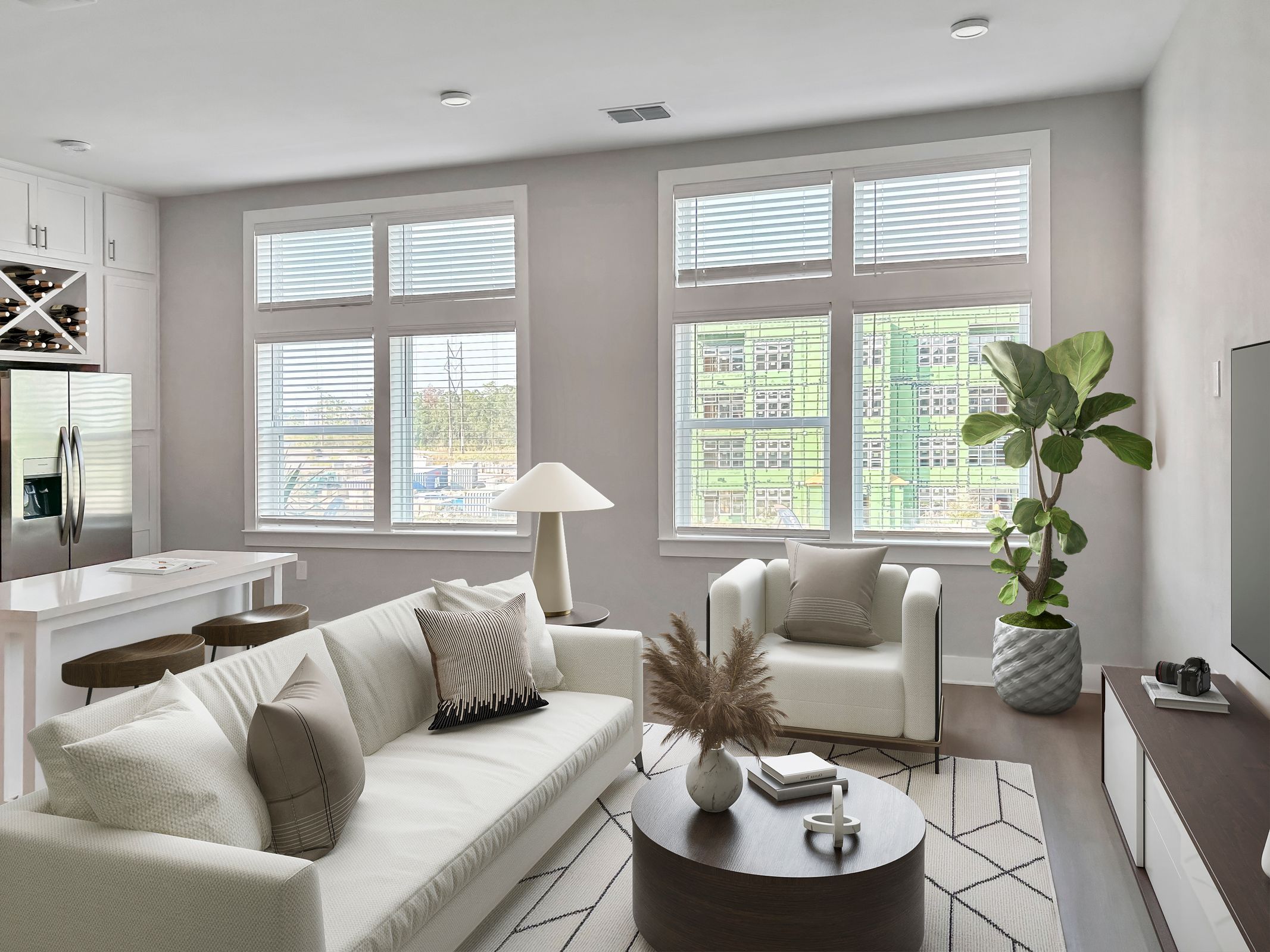 Living room with couch, chair, and indoor plants inside an apartment at The Lucent at Sunrise