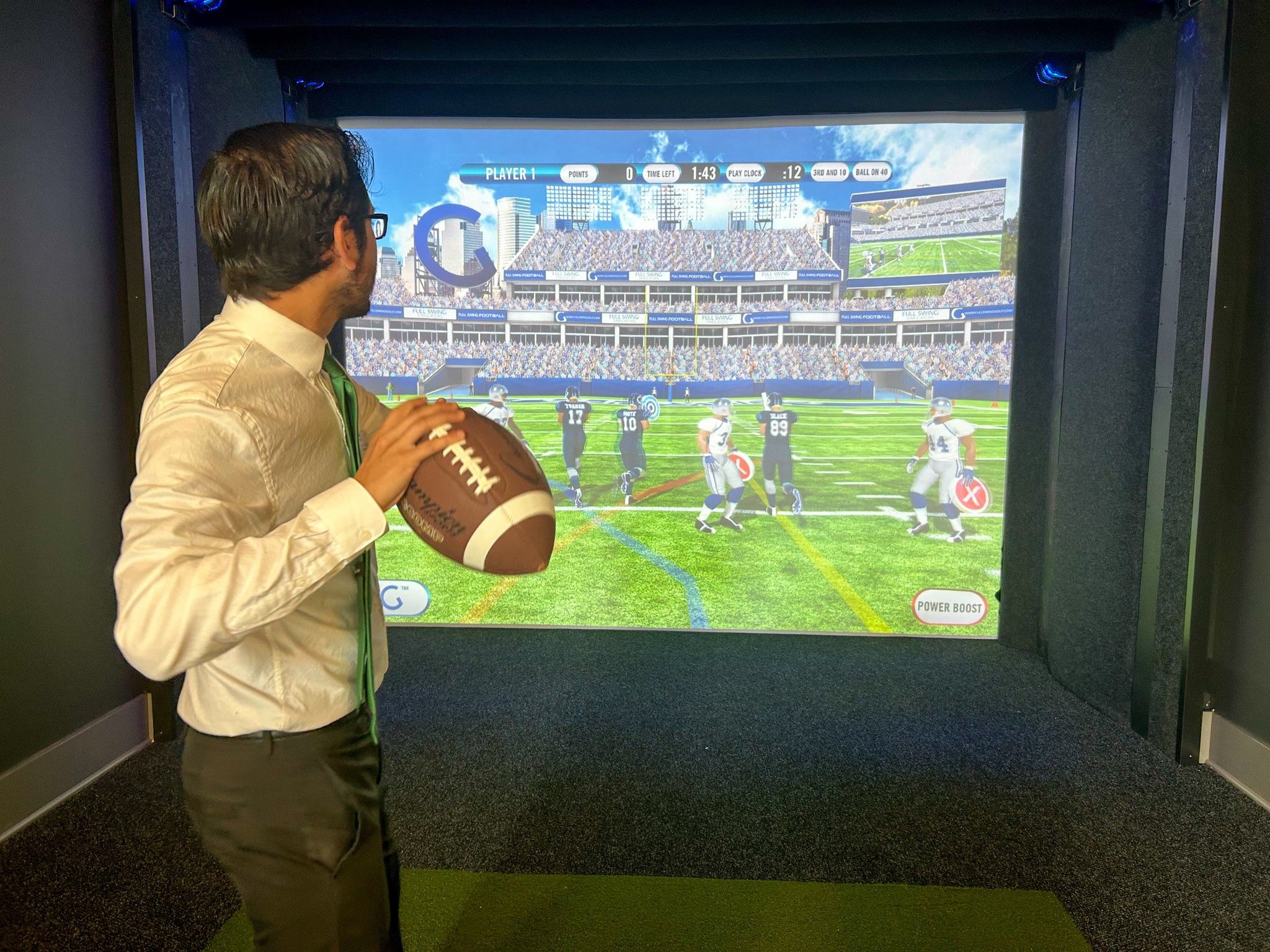 man holding football using sports simulator amenity at The Lucent at Sunrise apartments