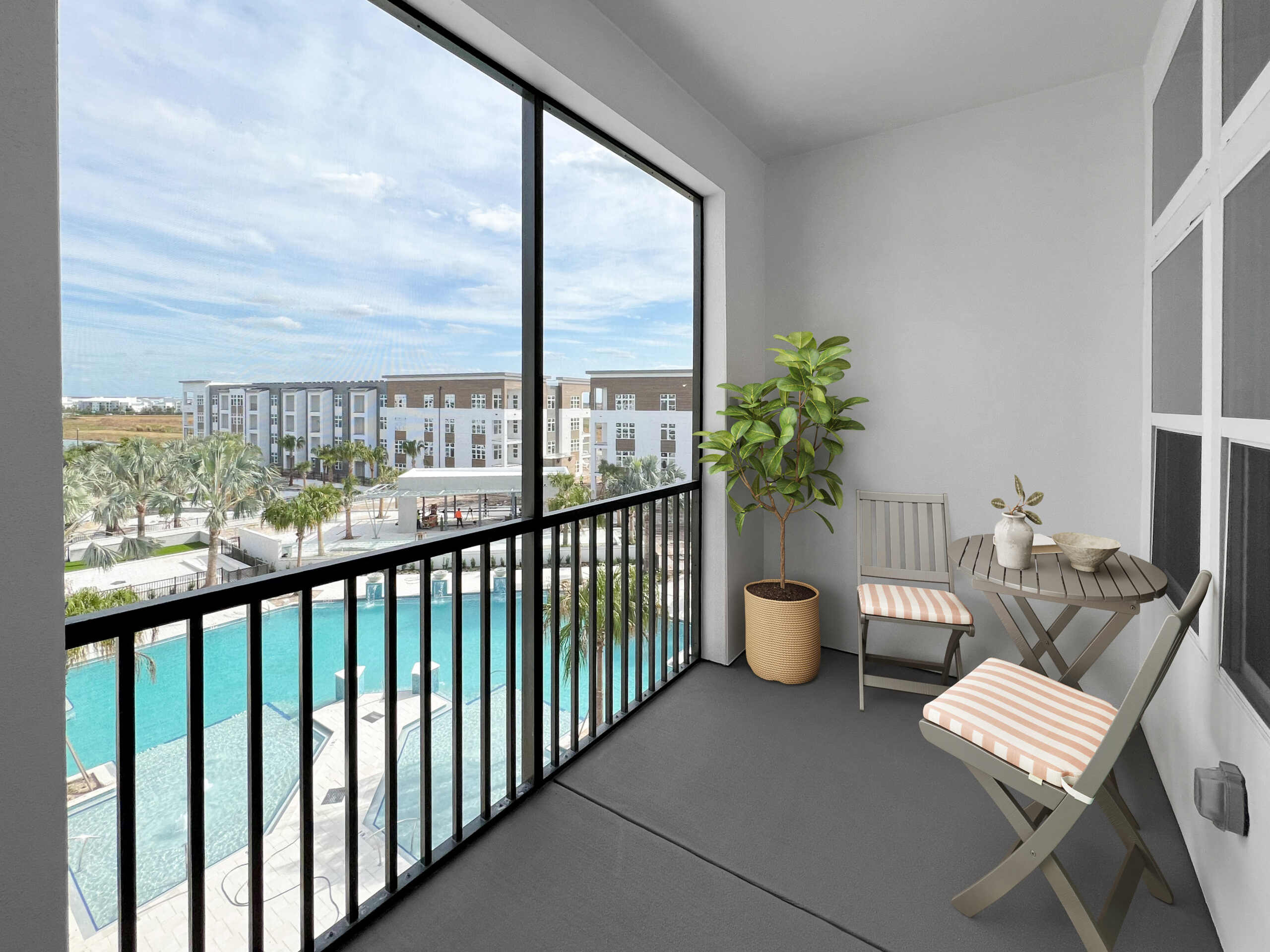 Living room with couch, chair, and indoor plants inside an apartment at The Lucent at Sunrise