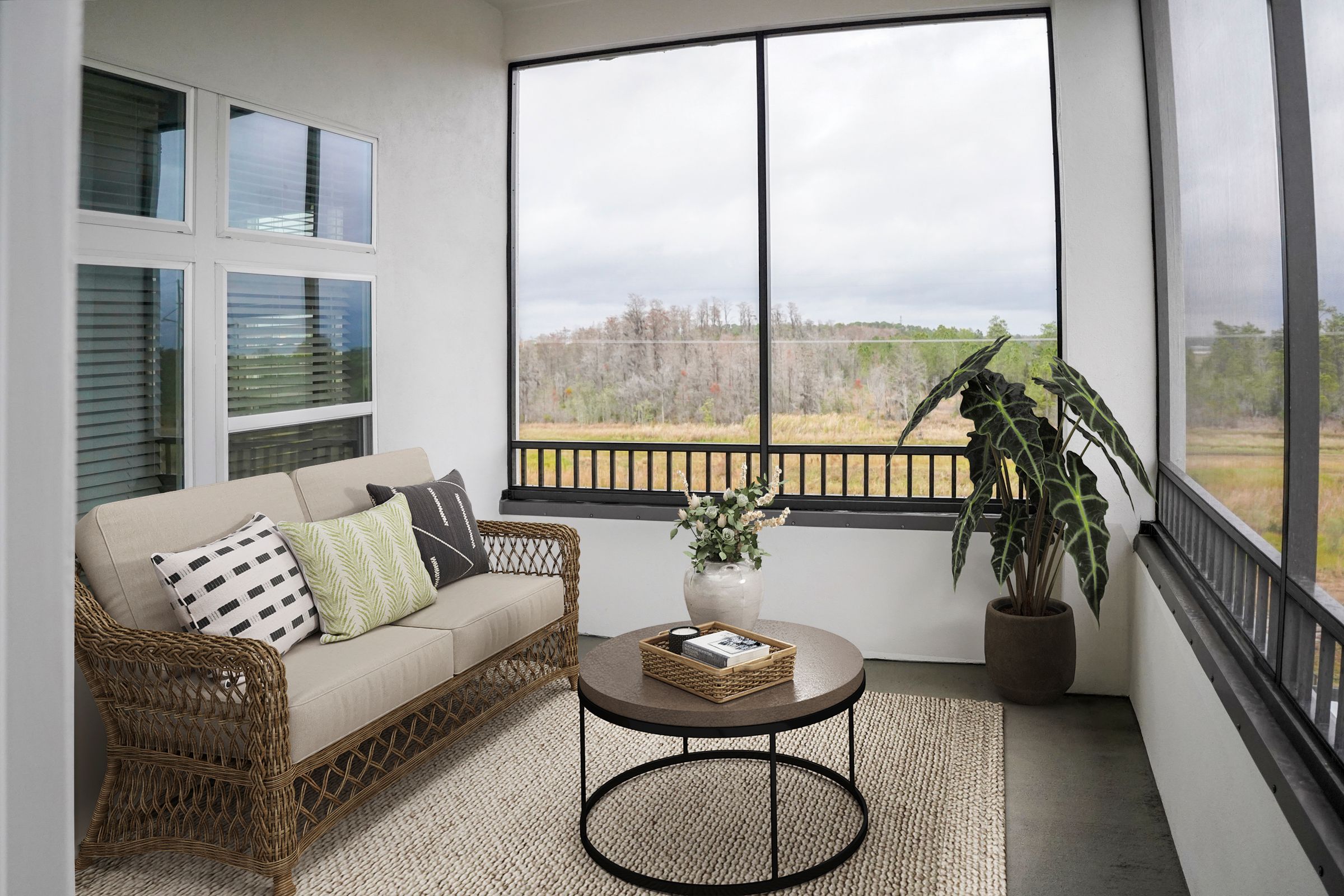 Living room with couch, chair, and indoor plants inside an apartment at The Lucent at Sunrise