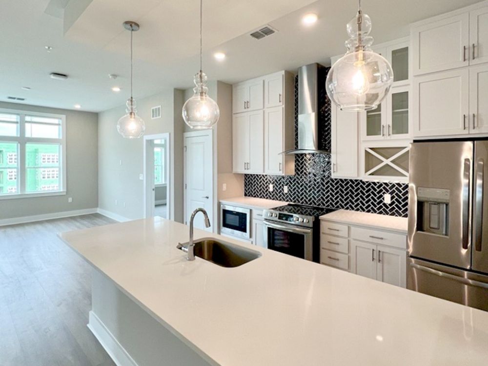 Kissimmee, FL apartment kitchen with designer lighting and elegant cabinetry