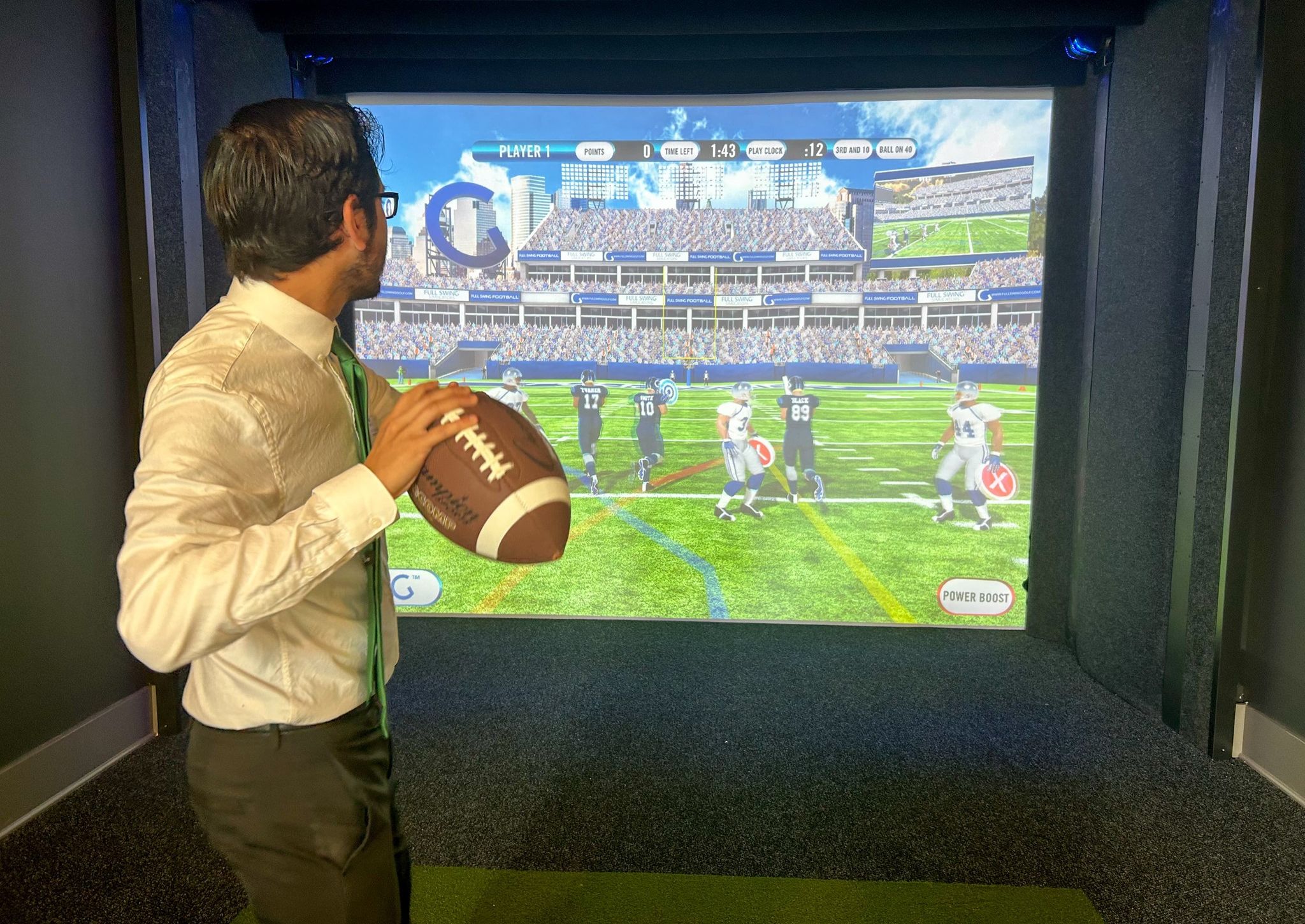 man holding football using sports simulator amenity at The Lucent at Sunrise apartments