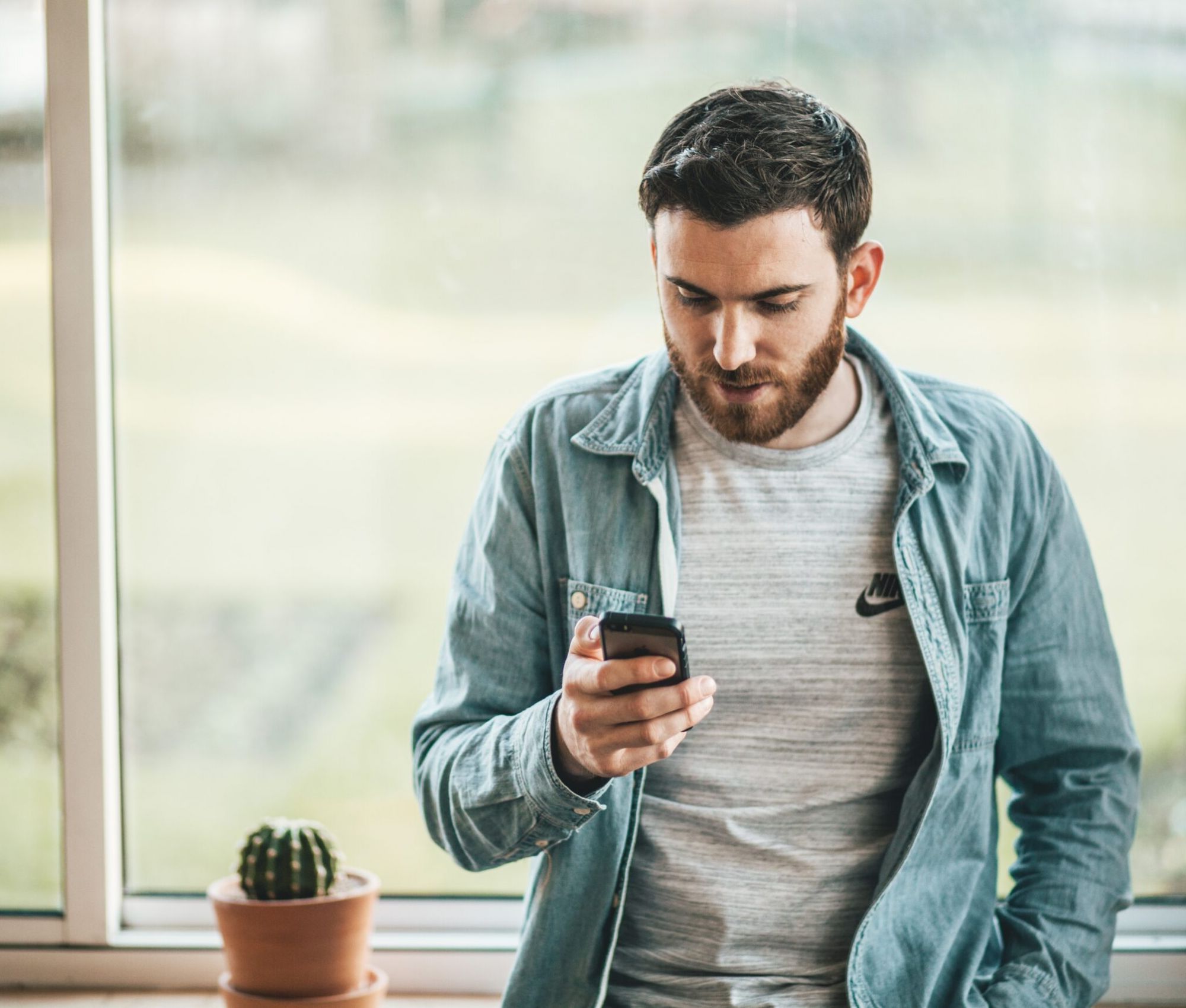 Man holding cell phone and typing on phone