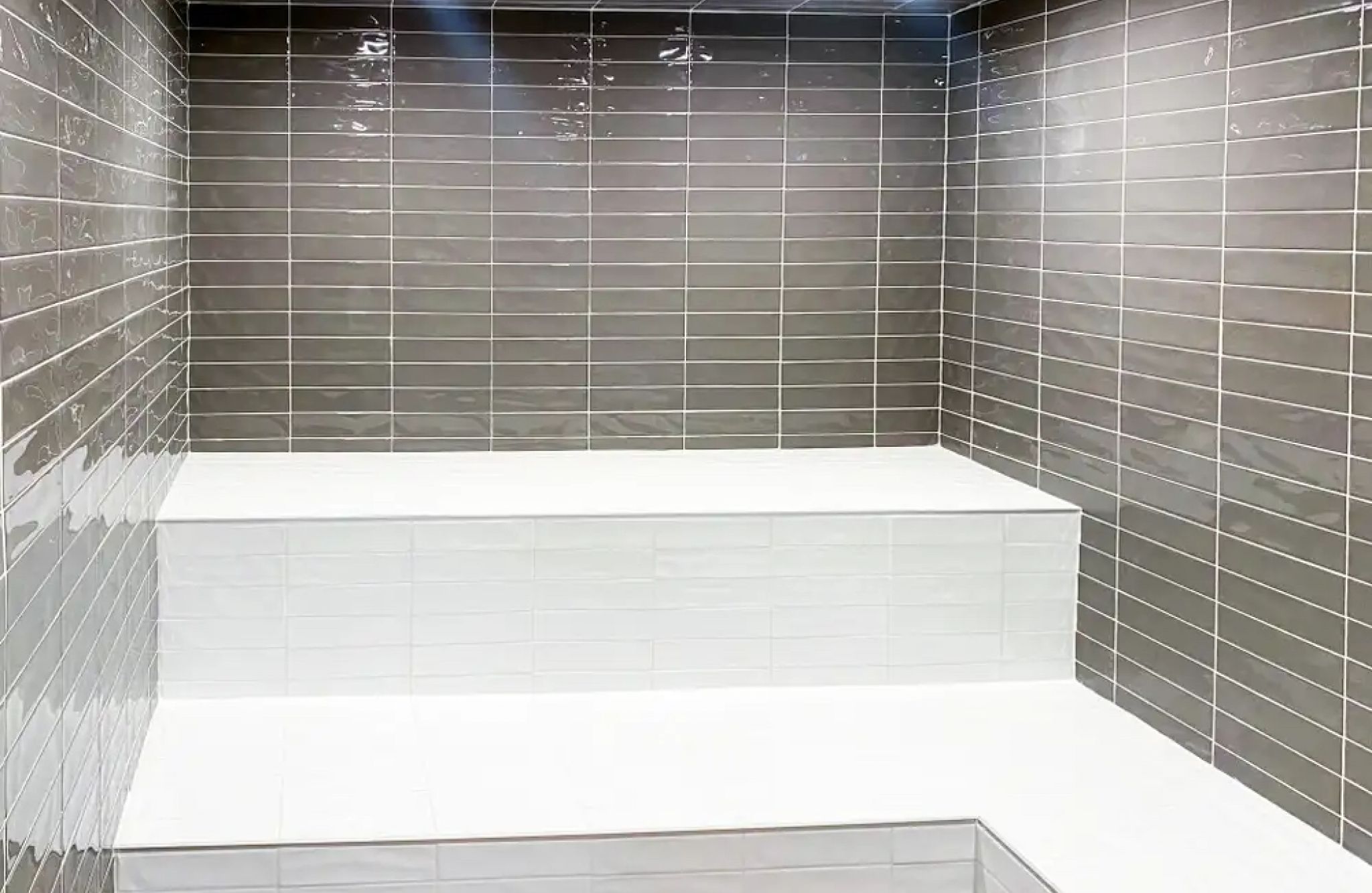 The Lucent steam room amenity with gray tile backsplash