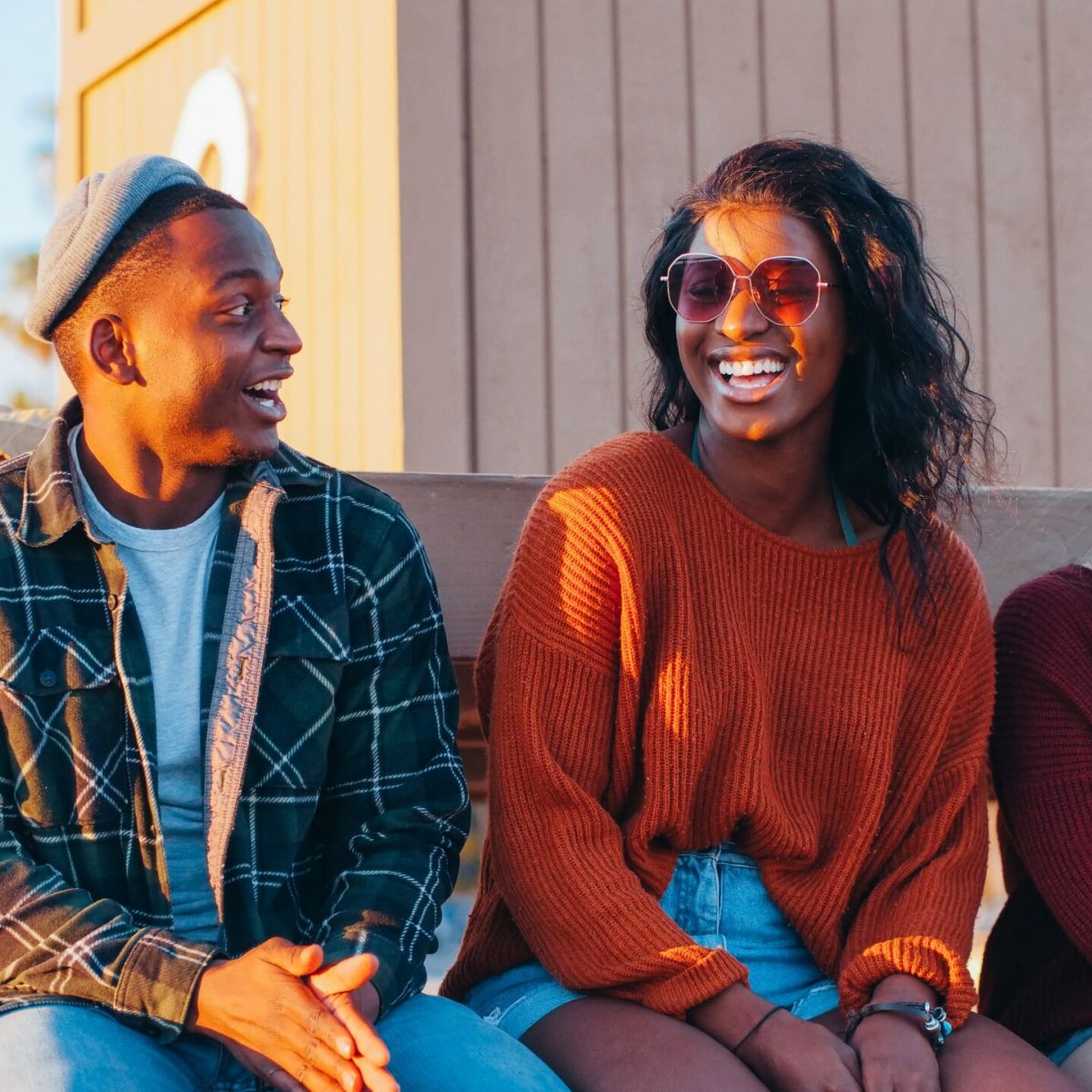 Friends sitting on a bench laughing and smiling